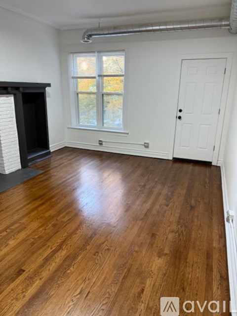 A room with wooden flooring and a white door.