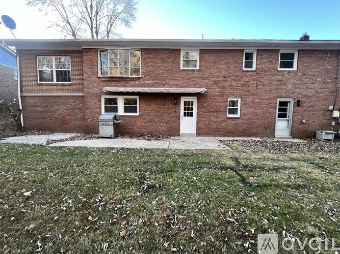 A red brick house with a white door and windows.