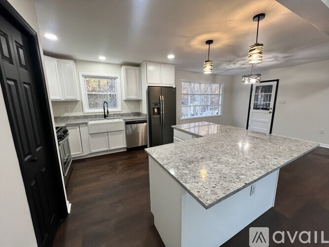 A kitchen with a granite countertop and a refrigerator.