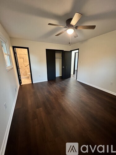 A room with a ceiling fan and wooden flooring.