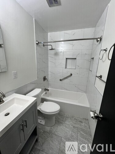 A bathroom with a toilet, sink, and bathtub.