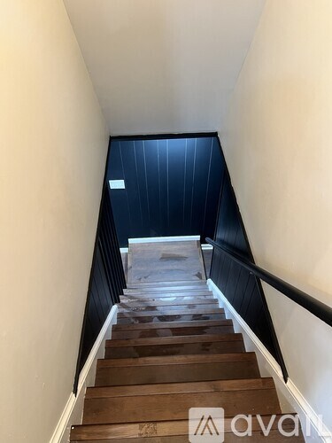 A staircase with wooden steps and a black railing.