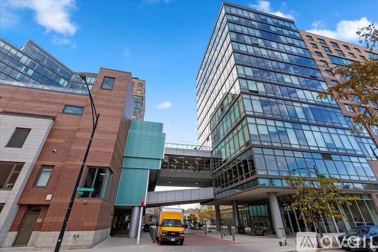 A modern building with glass windows and a truck parked in front.