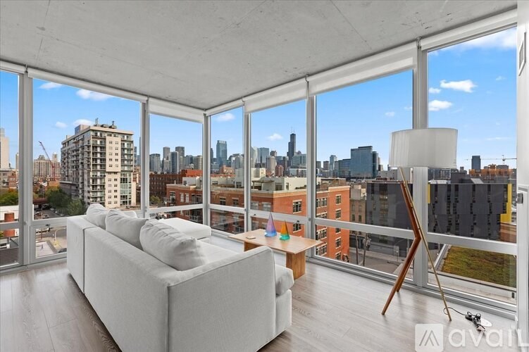 A white couch sits in a bright room with a view of the city.