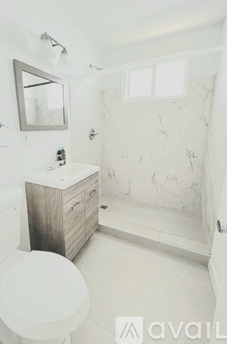 A bathroom with a toilet, sink, and shower.