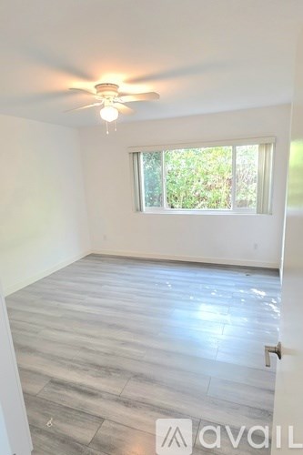 A room with a window and a ceiling fan.
