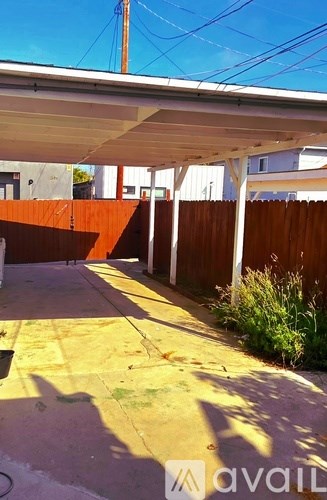 A patio area with a white roof and a wooden fence.