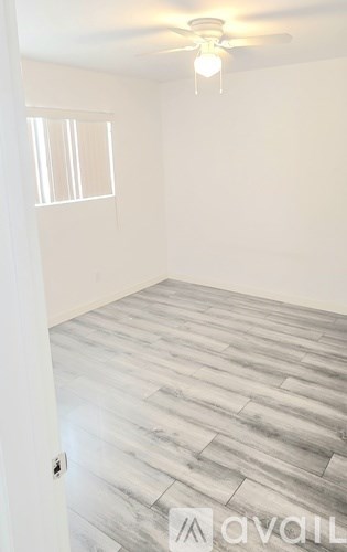 A room with a wooden floor and a ceiling fan.