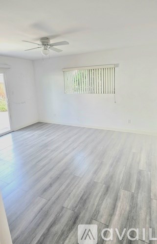 A room with a wooden floor and a ceiling fan.