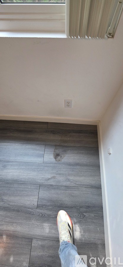 A person is standing on a wooden floor.