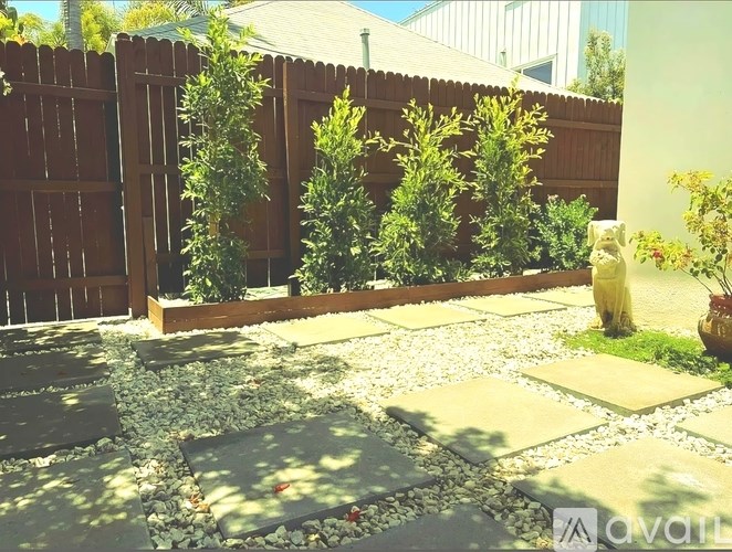 A garden with a wooden fence and a gravel path.