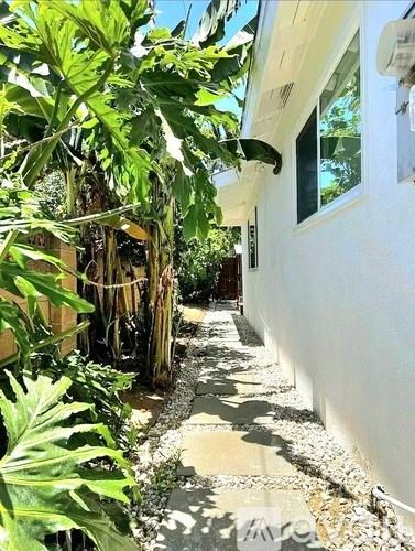 A white building with a small garden in front.