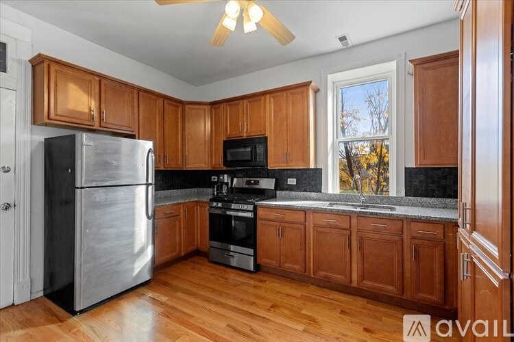A kitchen with wooden cabinets and a stainless steel refrigerator.