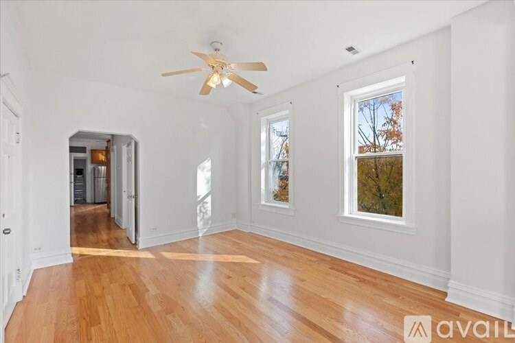 A room with a ceiling fan and wooden flooring.