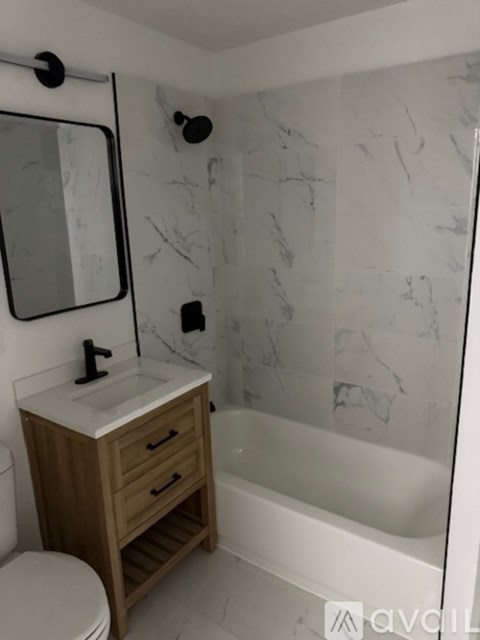 A bathroom with a marble wall and a wooden vanity.