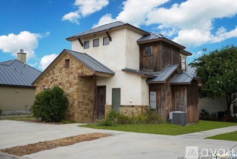 A house with a stone wall and a brown door.