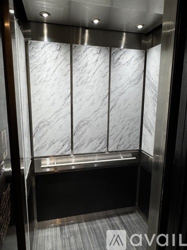 A marble wall in an elevator with Avail logo.