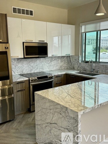 A kitchen with a marble countertop and stainless steel appliances.