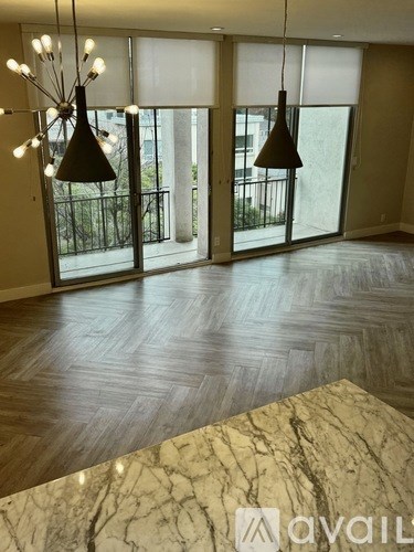 A living room with a marble table and wooden flooring.