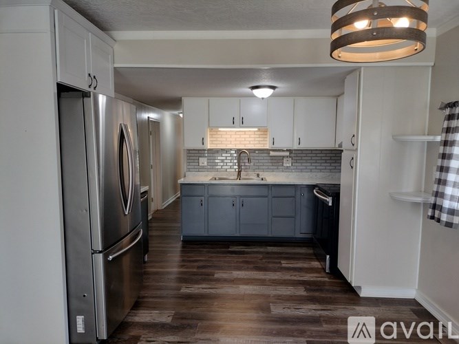 A kitchen with a refrigerator, cabinets, and a countertop.