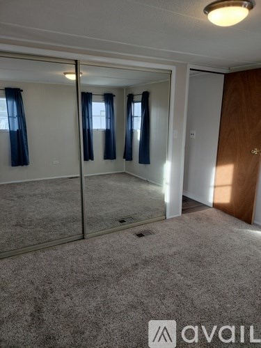 A carpeted room with a glass door and a wooden door.