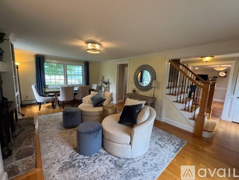 A living room with a grey rug and a white sofa.