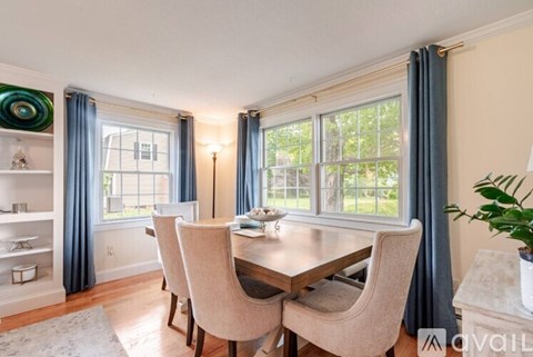 A dining room with a table and chairs.