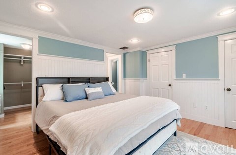 A bedroom with a large bed and a mirror on the wall.