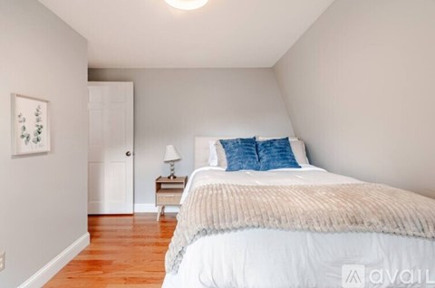 A bedroom with a bed, nightstand, and lamp.