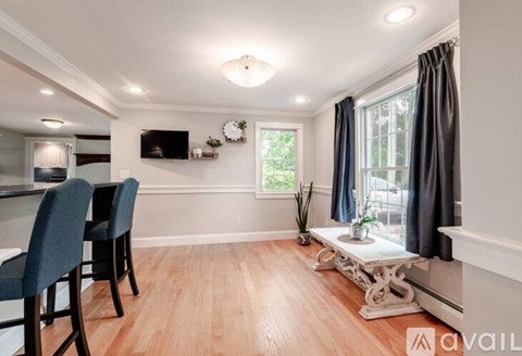 A living room with a television, two chairs, and a table.