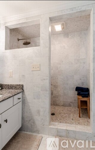 A bathroom with a shower and a vanity.