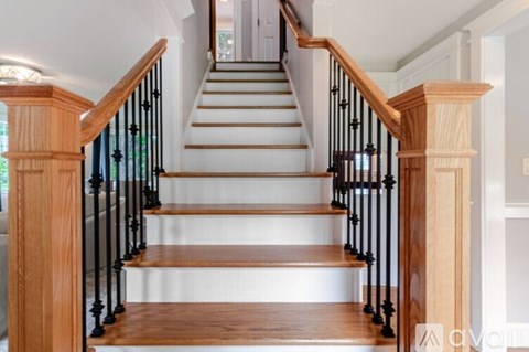 A wooden staircase with black metal railings.