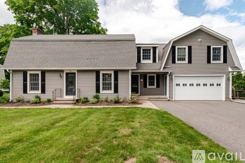 A house with a grey roof and a white garage door.