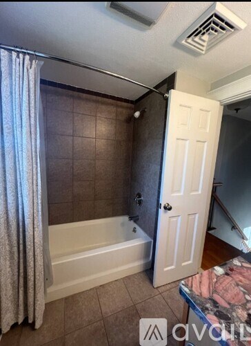 A bathroom with a white bathtub and a white door.