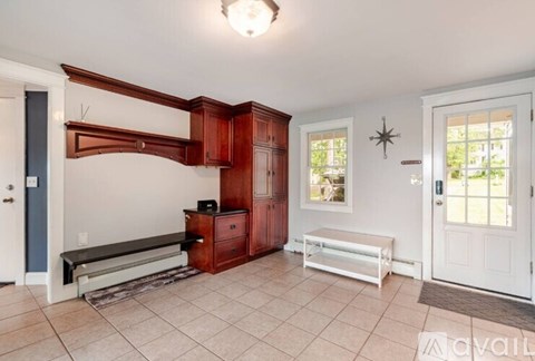 A room with a bench and a window.