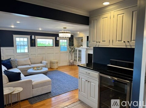 A modern kitchen with a white sofa and a chandelier.