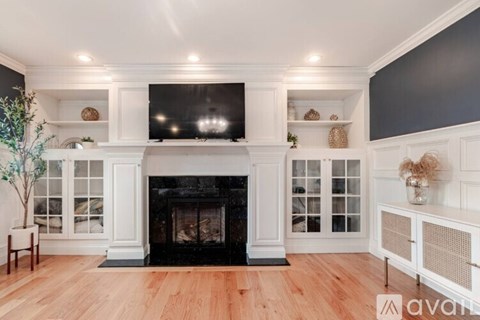 A well-lit living room with a fireplace and built-in shelves.