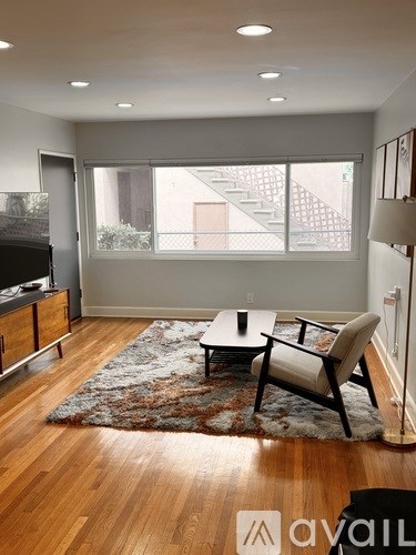 A living room with a couch, chair, and a rug.