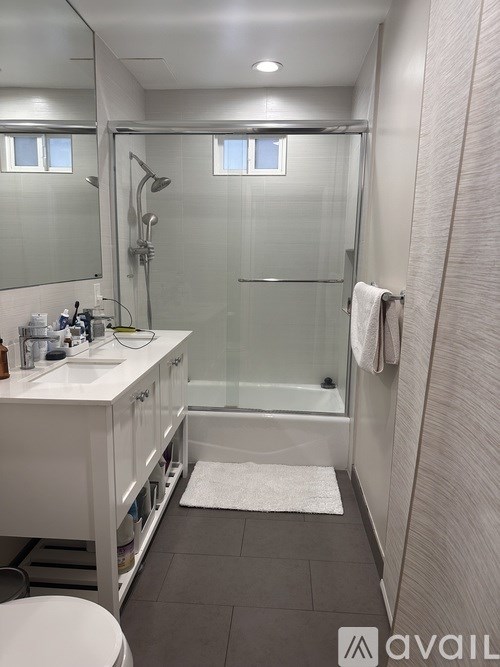 A bathroom with a white sink and a walk-in shower.