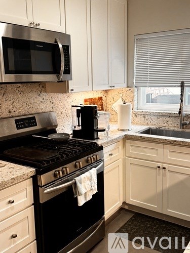 A kitchen with a black stove top oven and white cabinets.