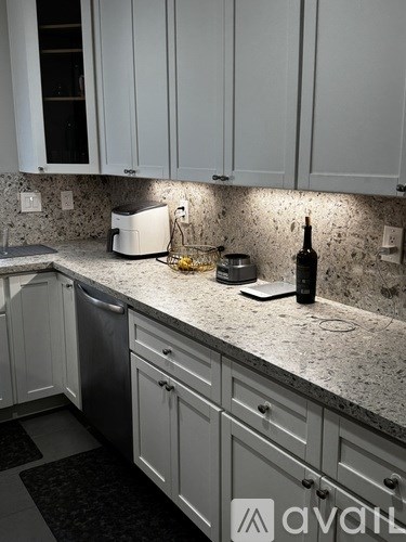 A kitchen with white cabinets and a granite countertop.