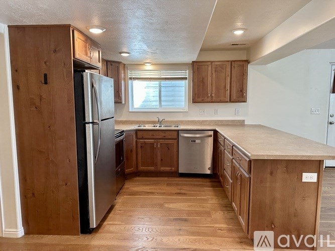A kitchen with wooden cabinets and a black refrigerator.