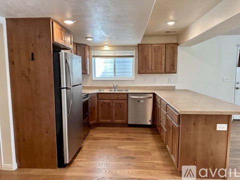 A kitchen with wooden cabinets and a black refrigerator.