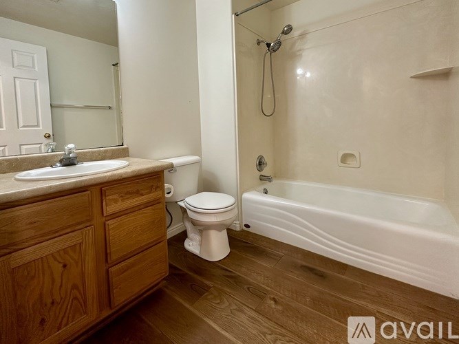 A bathroom with a white tub, sink, and toilet.