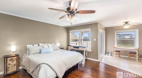 A bedroom with a large bed and a ceiling fan.