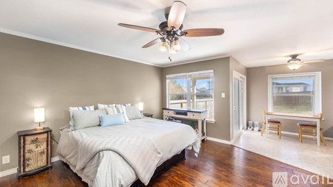 A bedroom with a large bed and a ceiling fan.