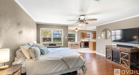 A bedroom with a large bed and a television in the corner.