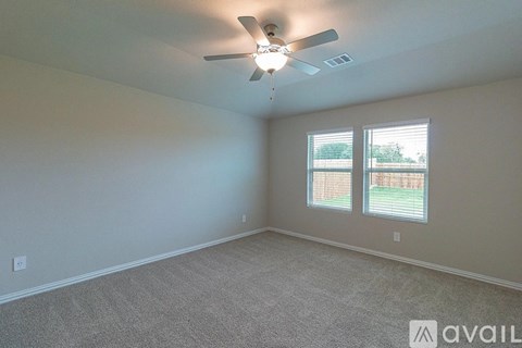 A room with a ceiling fan and carpeted floor.