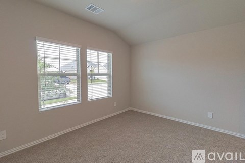 A room with two windows and a carpeted floor.