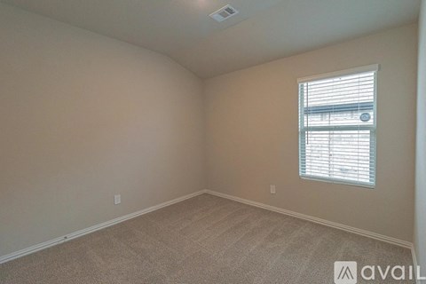 A room with a window and carpeted floor.
